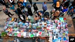 FILE - Iraqis shop for books and stationery along Al-Mutanabbi Street, home to the city's book market in central Baghdad, Feb. 1, 2019.