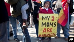 Gabriela Fore, 6, of Upper Darby Pa., holds a sign with her moms in front of the Supreme Court in Washington, Wednesday, Mar. 27, 2013, as the court heard arguments on the Defense of Marriage Act (DOMA).