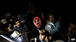 Raseljeni Sirijci čekaju hranu koju distribuira jedna nevladina organizacija u izbegličkom kampu kod Azaza. 