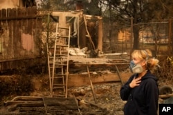 Lissa Renn mengamati sisa-sisa lingkungan tempat tinggalnya di Altadena, California, Kamis, 9 Januari 2025. (Foto: AP)