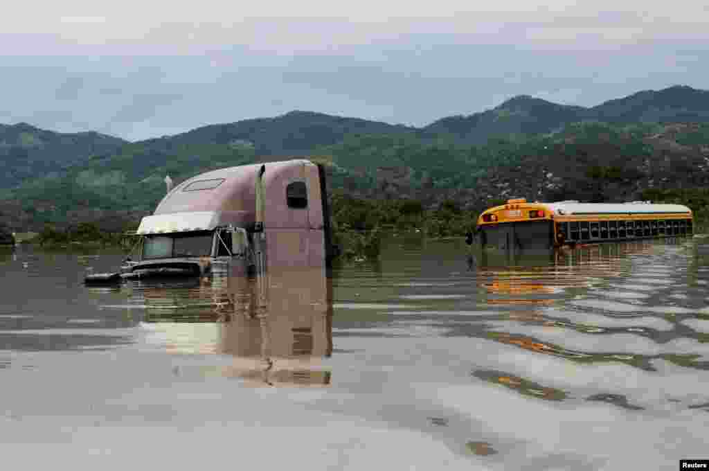 Camiones y autobuses parcialmente sumergidos se ven a lo largo de una calle inundada durante el paso de la tormenta Eta, en Pimienta, Honduras, el 5 de noviembre de 2020.