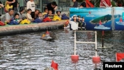 2018年6月2日，中国上海的一家公园，儿童玩耍遥控模型军舰。