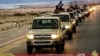 FILE - An image made available by propaganda Islamist media outlet Welayat Tarablos on Feb. 18, 2015, allegedly shows members of the Islamic State (IS) militant group parading in a street in Libya's coastal city of Sirte, which lies 500 kilometers (310 miles) east of the capital, Tripoli. 