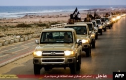 FILE - An image made available by propaganda Islamist media outlet Welayat Tarablos on Feb. 18, 2015, allegedly shows members of the Islamic State militant group parading in a street in Libya's coastal city of Sirte, which is 500 kilometers (310 miles) east of the capital, Tripoli.