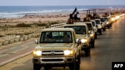 FILE - An image made available by propaganda Islamist media outlet Welayat Tarablos on February 18, 2015, allegedly shows members of the Islamic State (IS) militant group parading in a street in Libya's coastal city of Sirte.