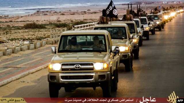 FILE - An image made available by propaganda Islamist media outlet Welayat Tarablos on Feb. 18, 2015, allegedly shows members of the Islamic State (IS) militant group parading in a street in Libya's coastal city of Sirte, which lies 500 kilometers (310 miles) east of the capital, Tripoli. 