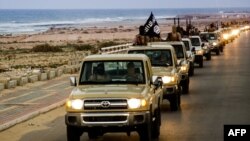 An image made available by propaganda Islamist media outlet allegedly shows members of the Islamic State parading in a street in Sirte, Libya.