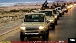 FILE - An image made available by propaganda Islamist media outlet Welayat Tarablos on Feb. 18, 2015, allegedly shows members of the Islamic State (IS) militant group parading in a street in Libya's coastal city of Sirte, which lies 500 kilometers (310 miles) east of the capital, Tripoli. 