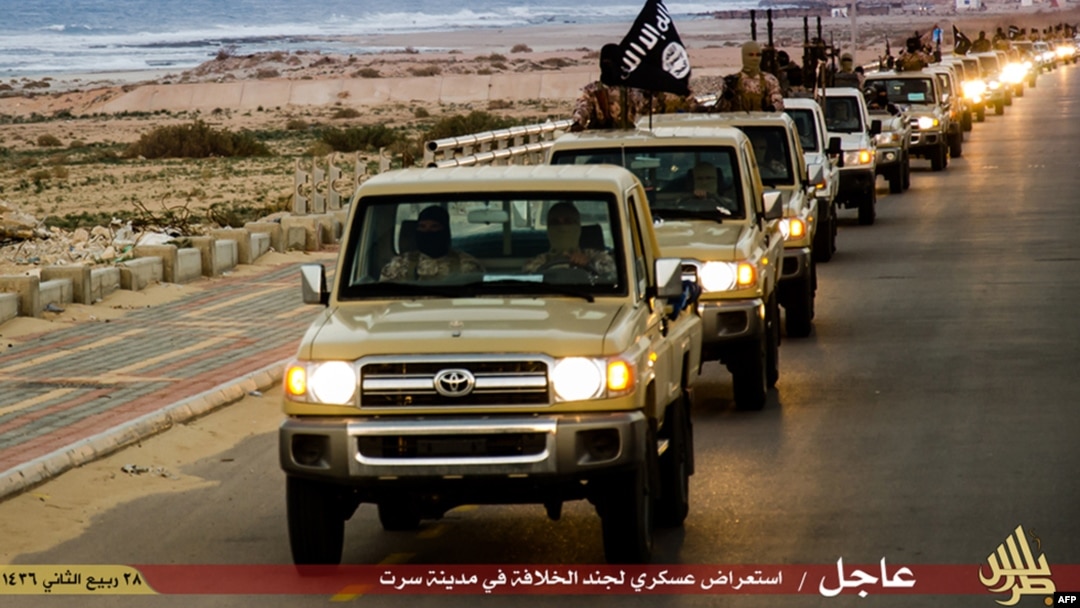 FILE - An image made available by propaganda Islamist media outlet Welayat Tarablos on Feb. 18, 2015, allegedly shows members of the Islamic State (IS) militant group parading in a street in Libya's coastal city of Sirte, which lies 500 kilometers (310 miles) east of the capital, Tripoli. 