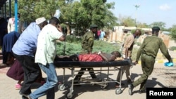 A man is transported on a stretcher after he was injured when a bus he was riding in drove onto a roadside bomb, near the Kenya-Somalia border in Mandera county, Kenya, Jan. 31, 2022. 