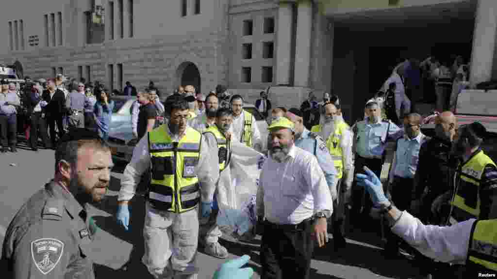 Equipa de pronto socorro israelita carrega um corpo do local do ataque, uma sinagoga em Jerusalém. Nov. 18, 2014.
