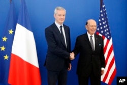 French Finance Minister Bruno Le Maire, left, welcomes US Secretary of Commerce Wilbur Ross prior to their meeting at French Economy Ministry in Paris, May 31, 2018.