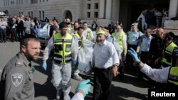 Israeli emergency personnel carry a covered body from the scene of an attack at a Jerusalem synagogue, Nov. 18, 2014. 