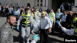 Israeli emergency personnel carry a covered body from the scene of an attack at a Jerusalem synagogue, Nov. 18, 2014. (REUTERS/Ammar Awad)