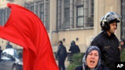 1月14日突尼斯抗议民众与安全部队发生冲突，一名妇女挥舞突尼斯国旗
