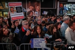 A woman holds a poster bearing a photo of Israeli hostage Tomer Ahimas as members of the Jewish community and supporters of Israel attend a rally calling for the release of hostages held by Hamas, in Times Square, New York on October 19, 2023.