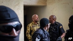 FILE - Uganda's state minister for finance in charge of planning Amos Lugoloobi is led into the courtroom where he pleaded not guilty to corruption offenses, in Kampala, Uganda, April 17, 2023.