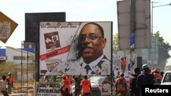 Un groupe d'opposants au président sénégalais Macky Sall vandalise un de ses posters à Thiès, au Sénégal, le 3 février 2019.