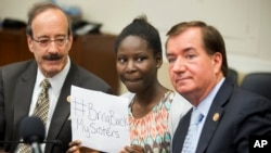 Cô Deborah Peter, giữa, người sống sót duy nhất trong lần Boko Haram tấn công gia đình cô, cùng Chủ tịch Ủy ban Ngoại vụ Hạ viện Ed Royce (phải) và thành viên cấp cao của Ủy ban Ngoại vụ Hạ viên thuộc đảng Dân chủ Eliot Engel có mặt trong phiên điều trần tại Trụ sở Quốc hội, 21/5/2014.