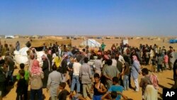 Suasana pembagian bantuan makanan dan obat-obatan di kamp pengungsii di Rukban, perbatasan Suriah-Yordania, 4 Agustus 2016. (Foto: dok).