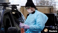Seorang petugas medis menyiapkan label-label untuk menandai sampel-sampel air liur di sebuah fasilitas lantatur tes Covid-19 di Salt Lake City, Utah, Sabtu, 14 November 2020. (Foto: Reuters)