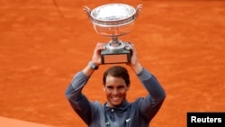 Spain's Rafael Nadal celebrates with the trophy after his final match against Austria's Dominic Thiem at the French Open, June 9, 2019.