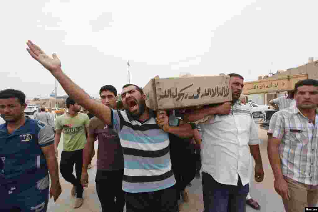 Relatives carry the coffin of an Iraqi police officer killed by militants, Najaf, Iraq, May 20, 2013.