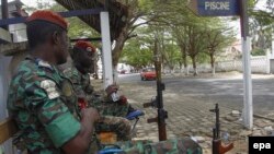 Des soldats ivoiriens sont assis près de l'Hotel Etoile du Sud à Grand Bassam, en Côte d'Ivoire, le 14 mars 2016.