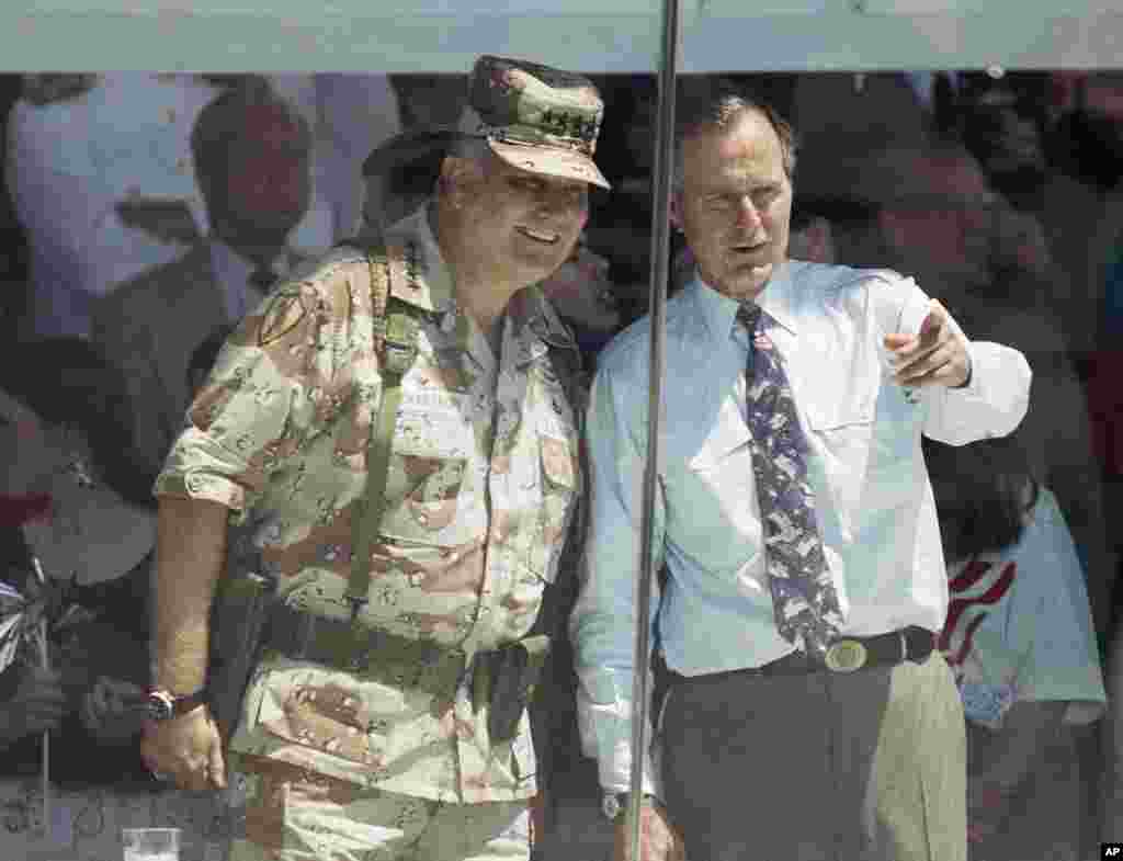 U.S. General Norman Schwarzkopf and then President George H. W. Bush watch the National Victory Parade from the viewing stand in Washington on June 8, 1991. 