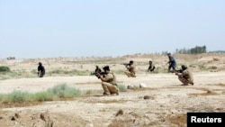 Members of Iraqi security forces take positions during a patrol looking for militants of the Islamic State of Iraq and the Levant (ISIL) west of Kerbala, June 29, 2014.