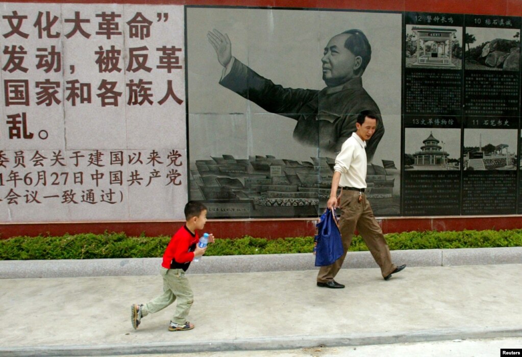 资料照：广东省汕头市举办文革展览，参观者走过的一幅毛泽东在文革期间的画像。（2007年4月25日）(photo:VOA)