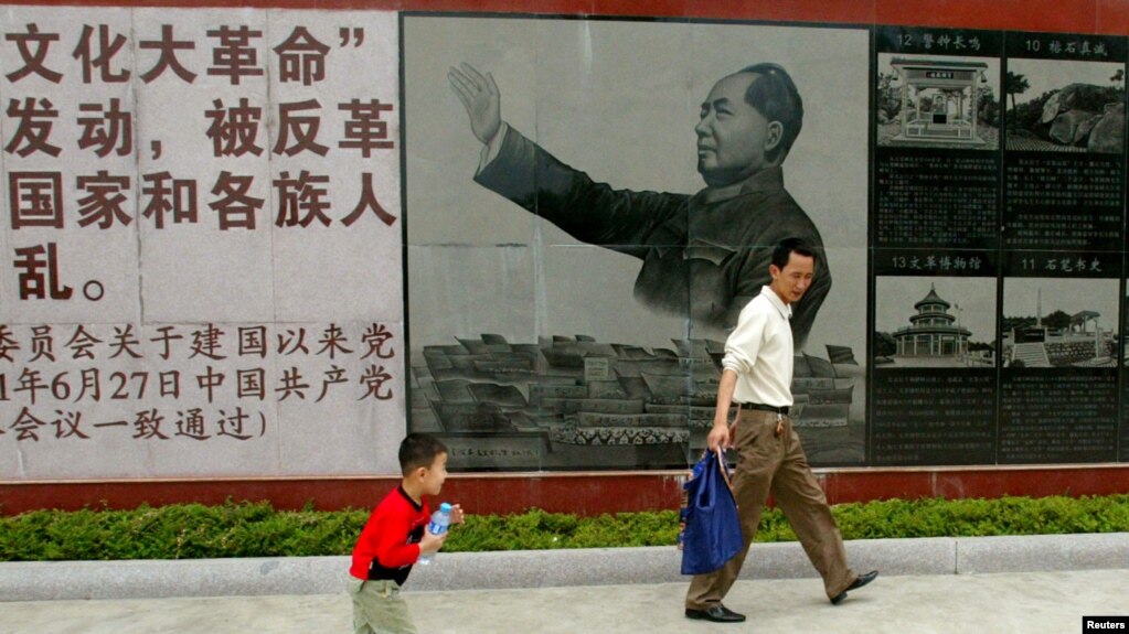 资料照：广东省汕头市举办文革展览，参观者走过的一幅毛泽东在文革期间的画像。（2007年4月25日）