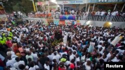Families and friends gather around a memorial at the site of a high-voltage wires' accident that left at least 16 people dead, during a vigil in Port-au-Prince, Haiti, Feb. 17, 2015. 