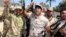 FILE - Volunteers, who have joined the Iraqi Army to fight against Sunni militant group Islamic State of Iraq and the Levant (ISIL), carry weapons during a parade in the city of Baquba, June 23, 2014.