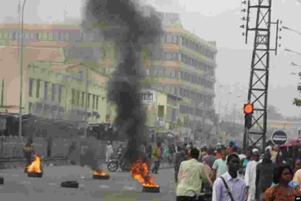 Civilians walk past burning tires lit in support of mutinying soldiers, in Bamako, Mali, March 21, 2012. (AP photo)