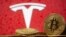 Representación de la moneda virtual Bitcoin vista frente al logo de Tesla. [Foto de archivo]