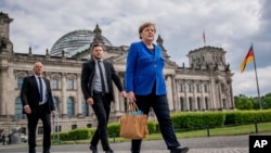 Chancellor Angela Merkel walks to the Chancellery, accompanied by her bodyguards, after the government questioning in the Bundestag in Berlin, Germany, May 13, 2020.