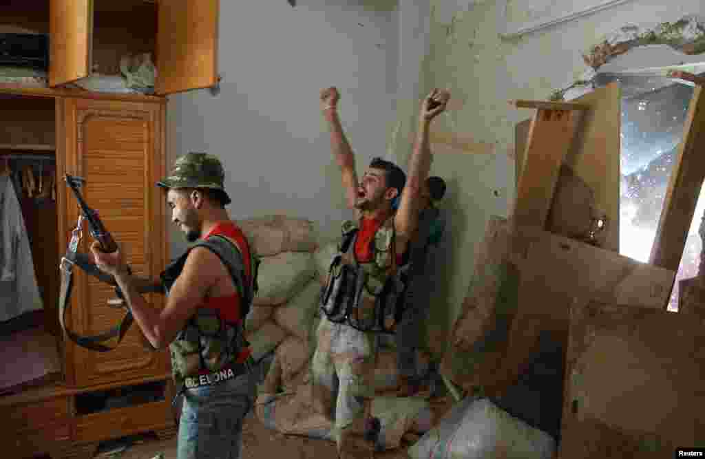 Free Syrian Army members react after they fire towards positions of pro-Bashar al-Assad forces in Deir al-Zor, July 7, 2013. 