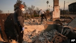 FILE - Kenneth Snowden, left, surveys the damage to his fire-ravaged property with his brother Ronnie in the aftermath of the Eaton fire, Jan. 10, 2025, in Altadena, Calif.