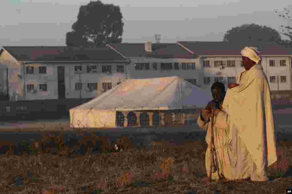 A woman and man pray before polling begins on election day in Harare, Zimbabwe Friday, June 27, 2008.