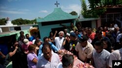 A family member laments the death of 64-year-old Reynalda Matus, as mourners prepare to bury her at the Miercoles Santo Cemetery in Juchitan, Oaxaca state, Mexico, Sept. 9, 2017. Matus was killed during a massive earthquake.