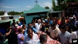 A family member laments the death of 64-year-old Reynalda Matus, as mourners prepare to bury her at the Miercoles Santo Cemetery in Juchitan, Oaxaca state, Mexico, Sept. 9, 2017. Matus was killed when the pharmacy where she worked nights collapsed during Thursday's massive earthquake. 