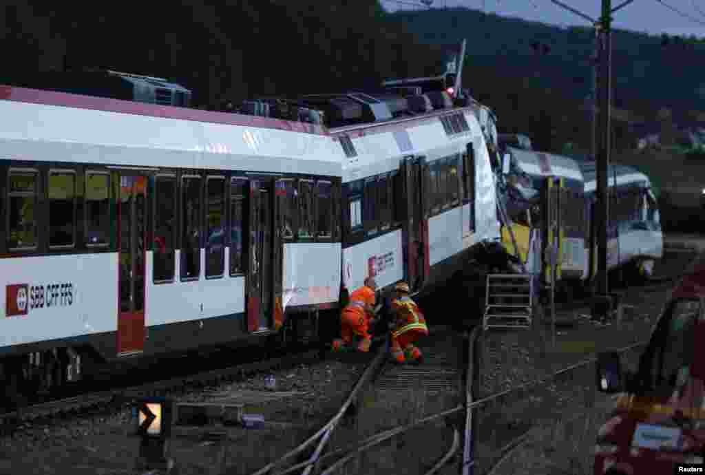 Rescue workers at the site of a head-on collision between two trains near Granges-pres-Marnand, Switzerland, July 29, 2013. 