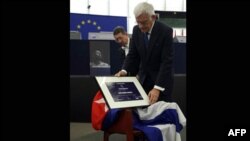Chiếc ghế trống dành cho ông Farinas phủ quốc kỳ Cuba và Giải thưởng Sakharov được đặt lên ghế trong buổi lễ trao giải tại Quốc hội Âu châu ở Strasbourg, Pháp