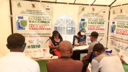 People wait to be registered before being vaccinated at the Palais des Sports vaccination centre in Yaounde on Jan. 6, 2022. - A Covid-19 vaccine is one of the keys to being able to go to the stadium.