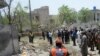 A rescue worker and security officials gather at the site after a deadly blast in residential area in Lahore, Pakistan, June 23, 2021. 