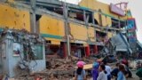Residents stand in front of a damaged shopping mall after an earthquake hit Palu, Sulawesi Island, Indonesia, Sept. 29, 2018.