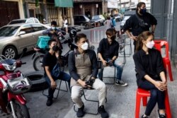 Pekerja bar di Bangkok menunggu tes COVID-19 sebelum memulai shift mereka, 6 Januari 2022. (Jack TAYLOR / AFP)