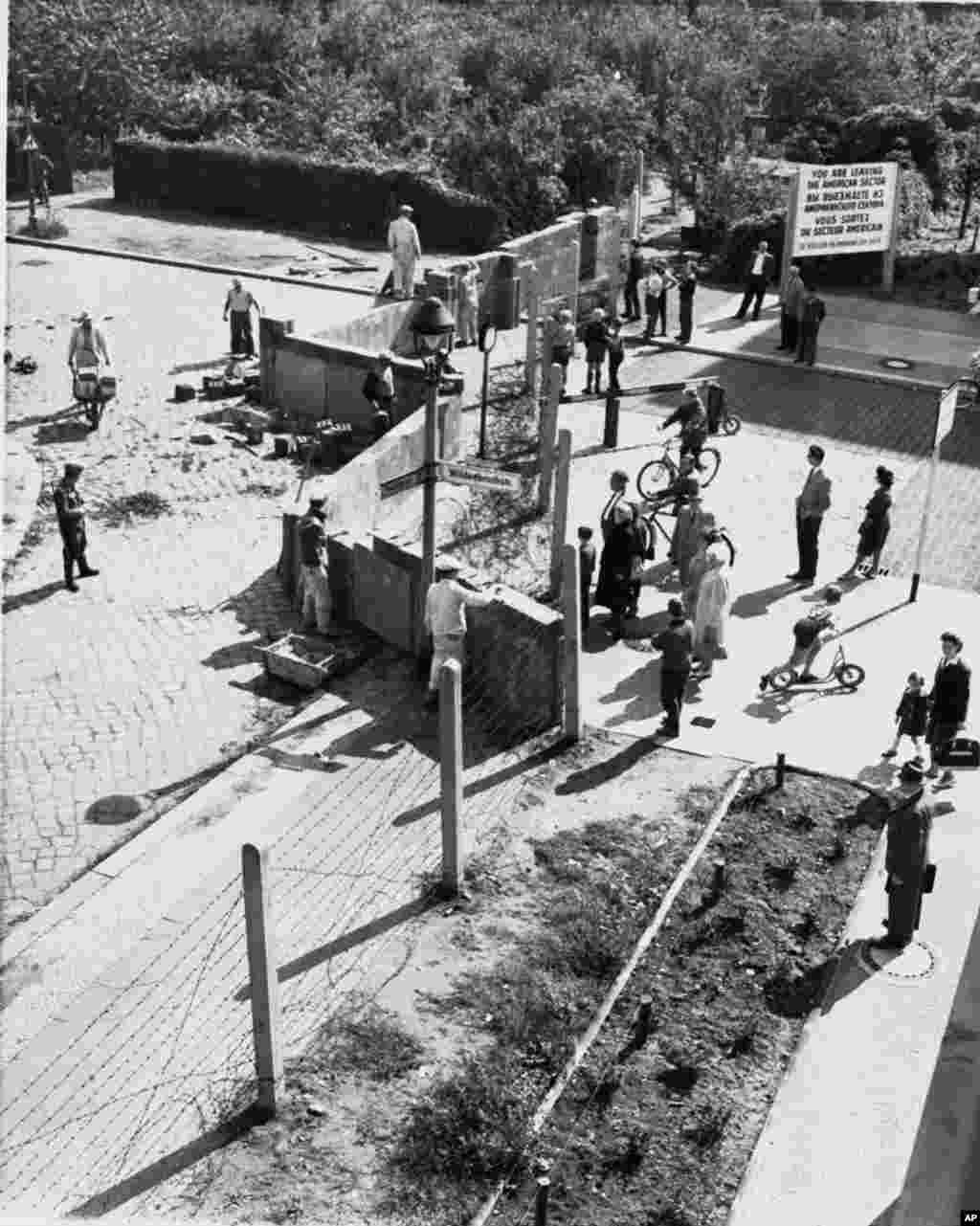 ARCHIV - Westberliner schauen im August 1961 Ostberliner Arbeitern bei der Errichtung der Berliner Mauer an der Wildenbruchstrasse und Heidelbergerstrasse zu. Am Donnerstag, den 13. August 2009, jaehrt sich der offizielle Tag des Mauerbaus zum 48. Mal. (