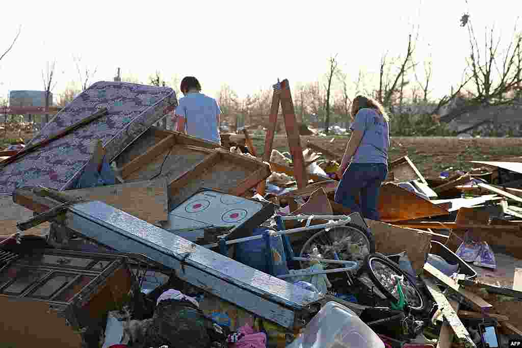 People walk through debris caused by a tornado that blasted Harrisburg, Illinois, February 29, 2012. (AP)